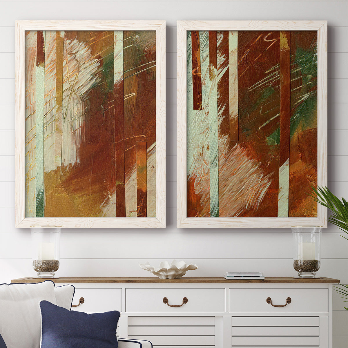 Set of two white barnwood framed canvas prints depicting a coordinated art pair of rust orange black cream and green brush bands rendered as earthy modern abstracts above a dining room sideboard.