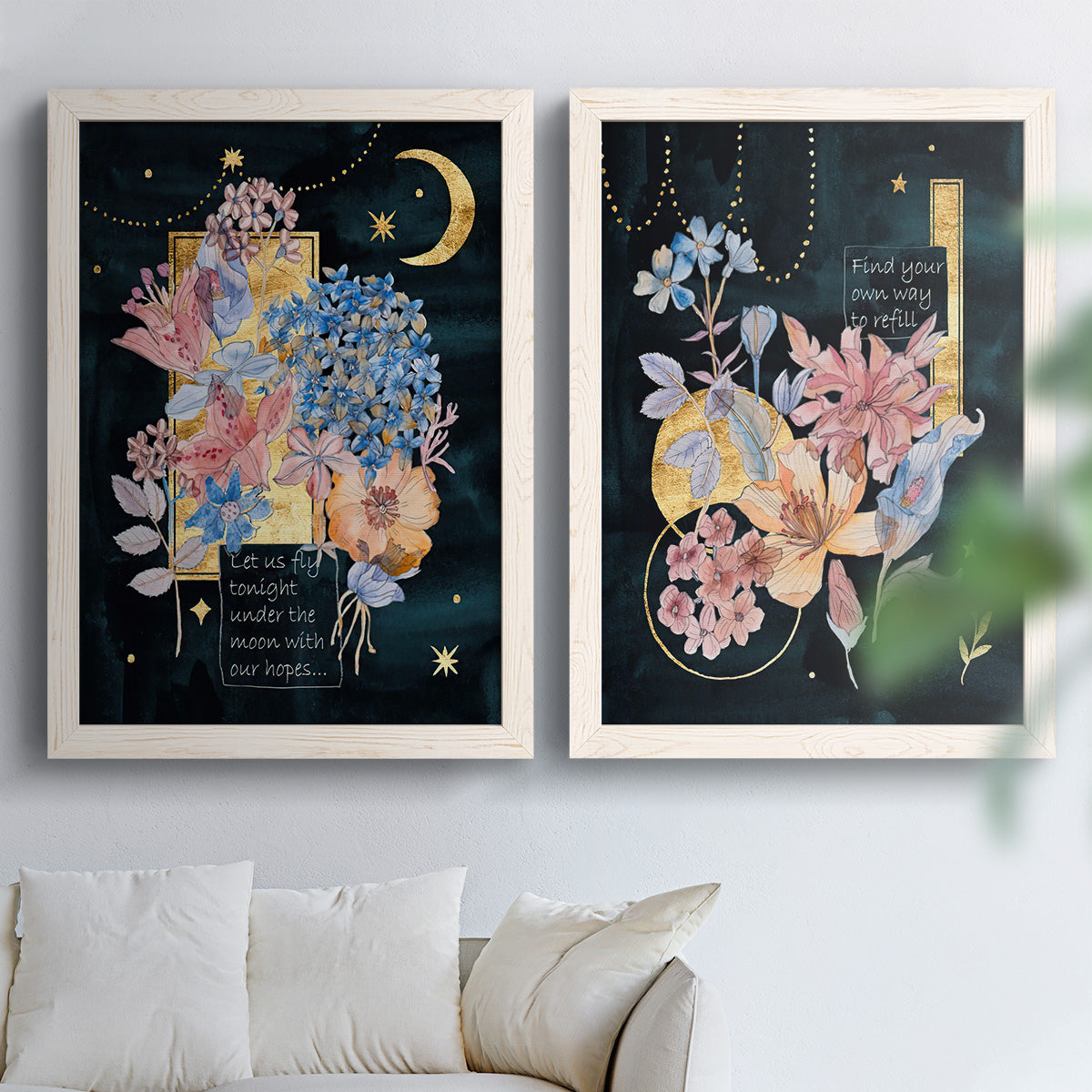Set of two white barnwood framed canvas prints depicting moons stars hanging jewels colorful blossoms and hand-lettered phrases arranged across two complementary compositions above a sofa in a bright living space.