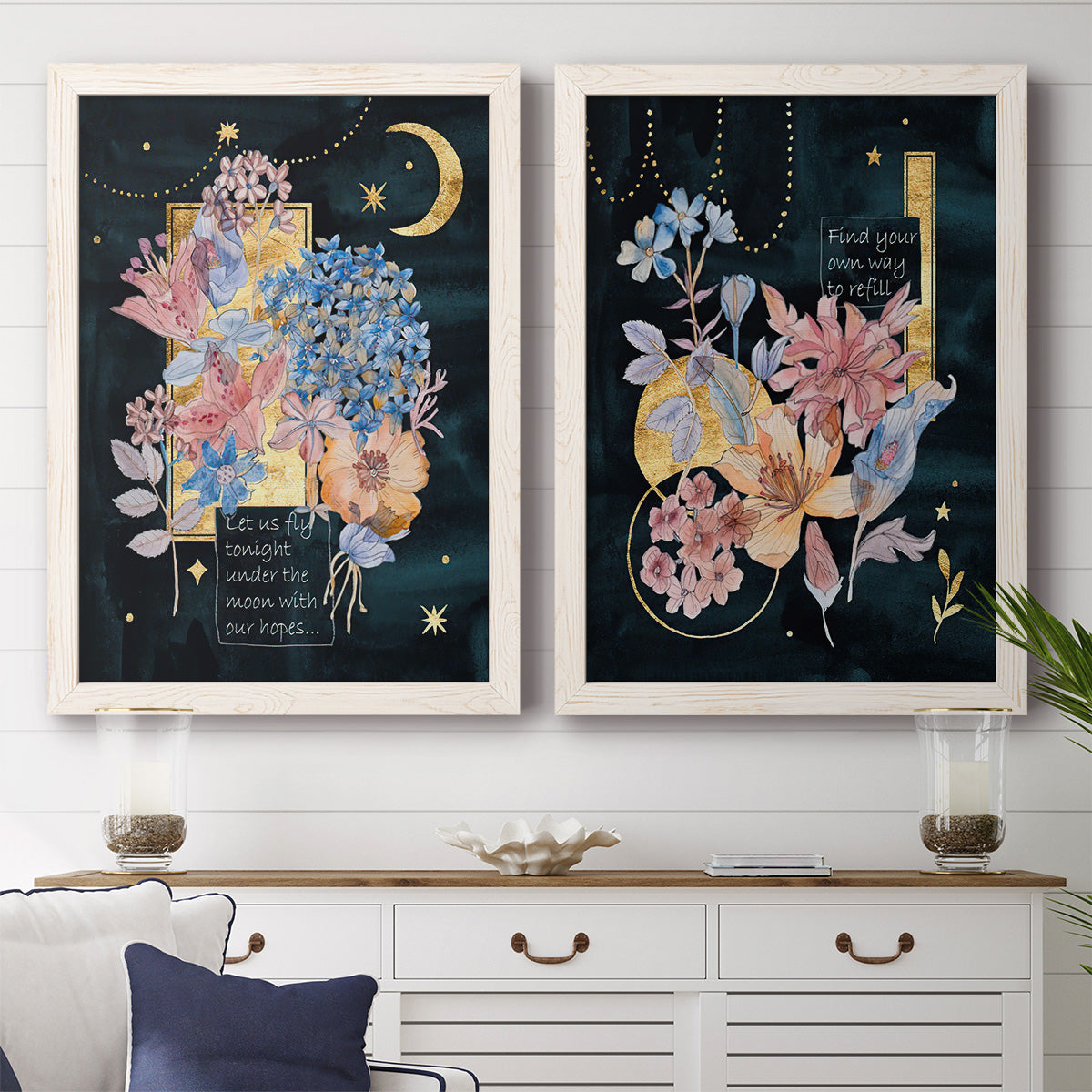 Set of two white barnwood framed canvas prints depicting a coordinated art pair of fantastical bouquets and celestial symbols on black rendered as whimsical floral collages above a dining room sideboard.