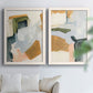 Set of two white barnwood framed canvas prints depicting broad geometric marks, soft overlaps, and restrained warm accents arranged across two complementary compositions above a sofa in a bright living space.
