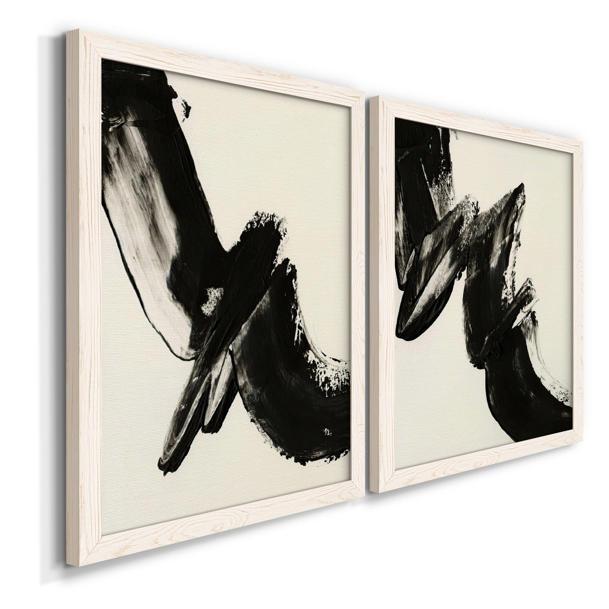 Angled view of a set of two white barnwood framed canvas prints featuring two bold gestural abstracts featuring sweeping black calligraphic brushstrokes.