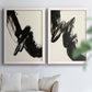 Set of two white barnwood framed canvas prints depicting thick ink-like marks, feathered edges, and cream negative space arranged across two complementary compositions above a sofa in a bright living space.
