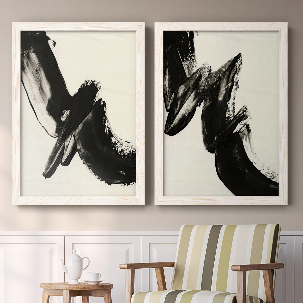 Set of two white barnwood framed canvas prints depicting two bold gestural abstracts featuring sweeping black calligraphic brushstrokes above a sideboard in a cozy sitting room.