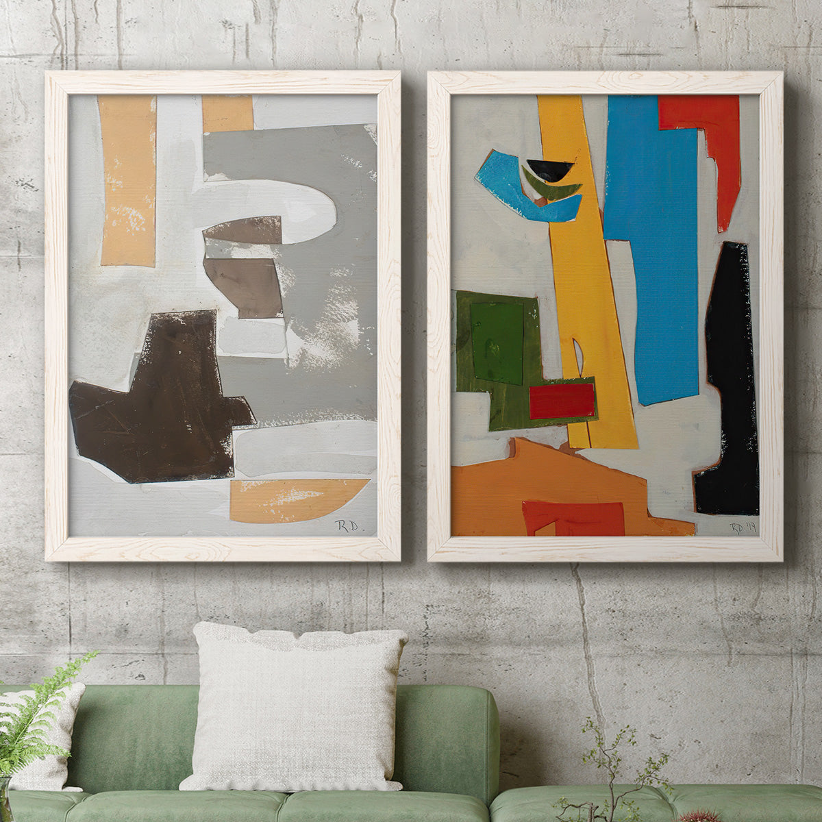 Set of two white barnwood framed canvas prints depicting a coordinated art pair of stacked gray cream blue and bright geometric blocks rendered as mid-century geometric abstracts above a sofa in a modern living room.