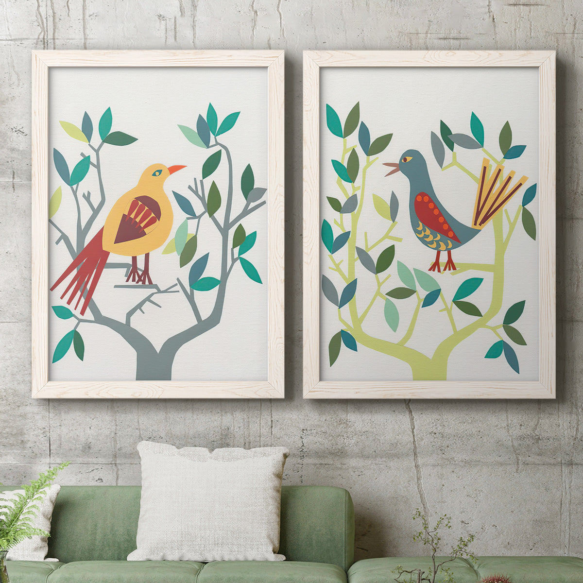 Set of two white barnwood framed canvas prints depicting a coordinated art pair of stylized colorful birds perched among leafy branches rendered as modern folk-art bird illustrations above a sofa in a modern living room.