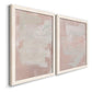 Angled view of a set of two white barnwood framed canvas prints featuring two minimalist color-field abstracts featuring soft blush and white painterly fields.