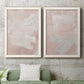 Set of two white barnwood framed canvas prints depicting a coordinated art pair of soft blush and white painterly fields rendered as minimalist color-field abstracts above a sofa in a modern living room.