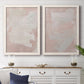 Set of two white barnwood framed canvas prints depicting a coordinated art pair of soft blush and white painterly fields rendered as minimalist color-field abstracts above a dining room sideboard.