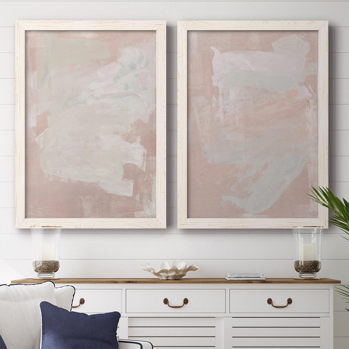 Set of two white barnwood framed canvas prints depicting a coordinated art pair of soft blush and white painterly fields rendered as minimalist color-field abstracts above a dining room sideboard.