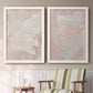 Set of two white barnwood framed canvas prints depicting two minimalist color-field abstracts featuring soft blush and white painterly fields above a sideboard in a cozy sitting room.
