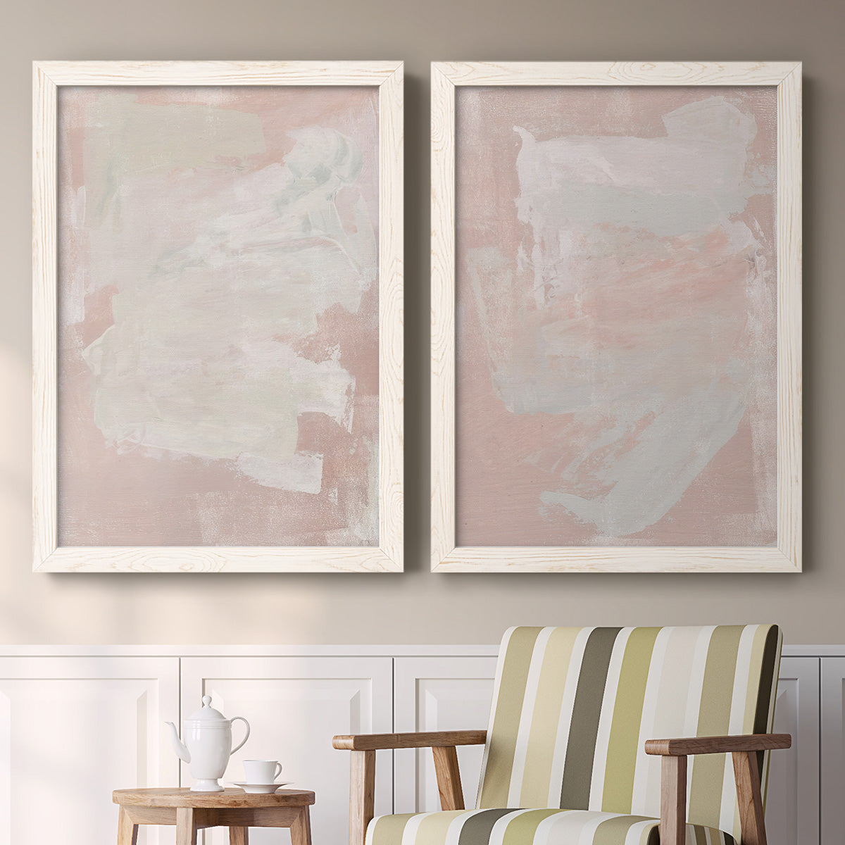 Set of two white barnwood framed canvas prints depicting two minimalist color-field abstracts featuring soft blush and white painterly fields above a sideboard in a cozy sitting room.