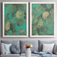 Set of two white barnwood framed canvas prints depicting paired textured organic abstracts with overlapping orbs, translucent prints, and weathered green grounds above a sofa in a contemporary living room.