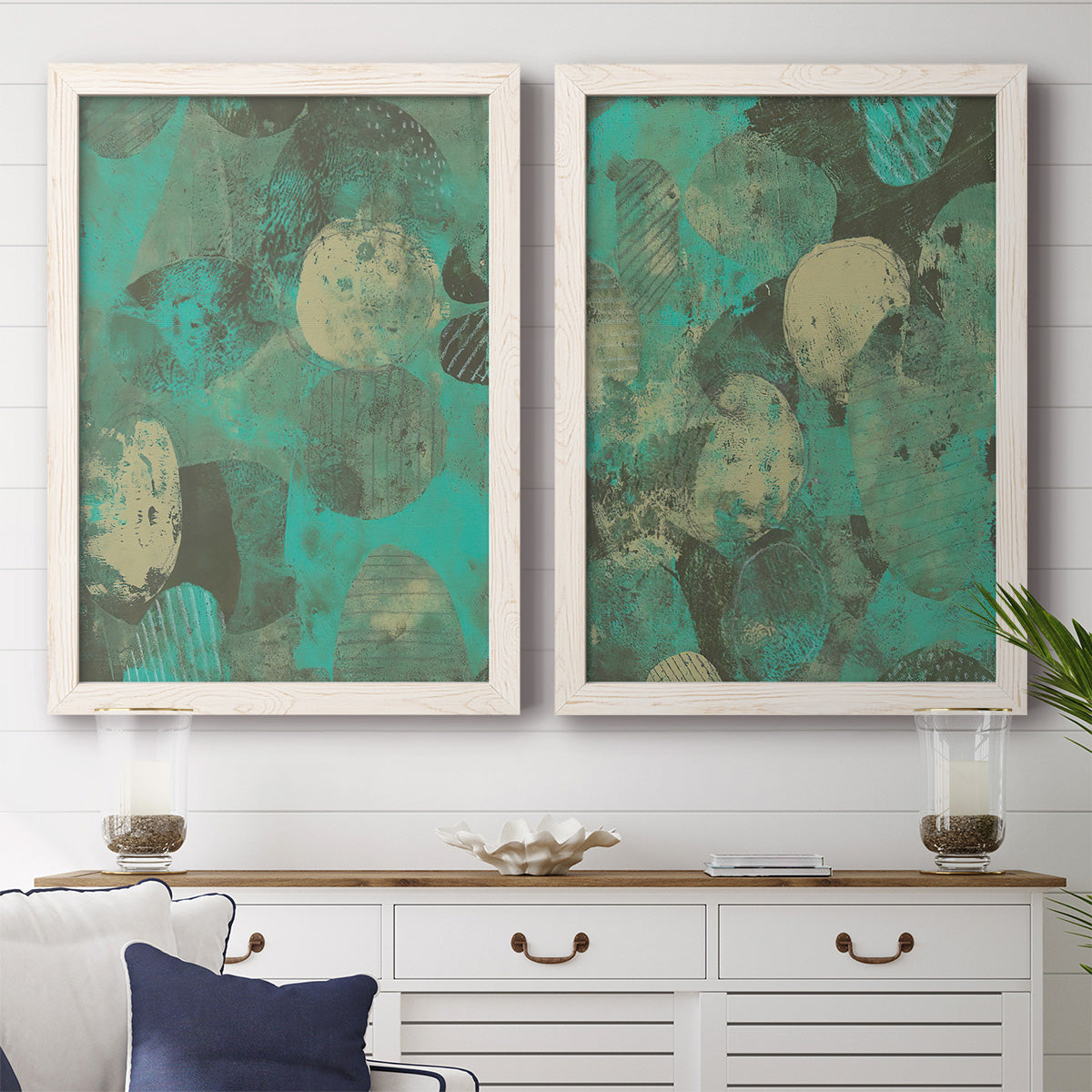 Set of two white barnwood framed canvas prints depicting a coordinated art pair of layered mint teal and beige circular forms rendered as textured organic abstracts above a dining room sideboard.