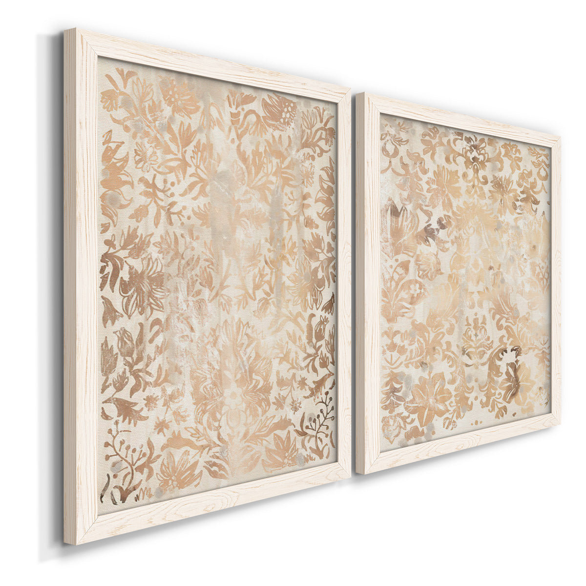 Angled view of a set of two white barnwood framed canvas prints featuring two vintage decorative prints featuring ornate cream floral damask patterns.
