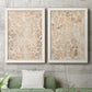 Set of two white barnwood framed canvas prints depicting a coordinated art pair of ornate cream floral damask patterns rendered as vintage decorative prints above a sofa in a modern living room.
