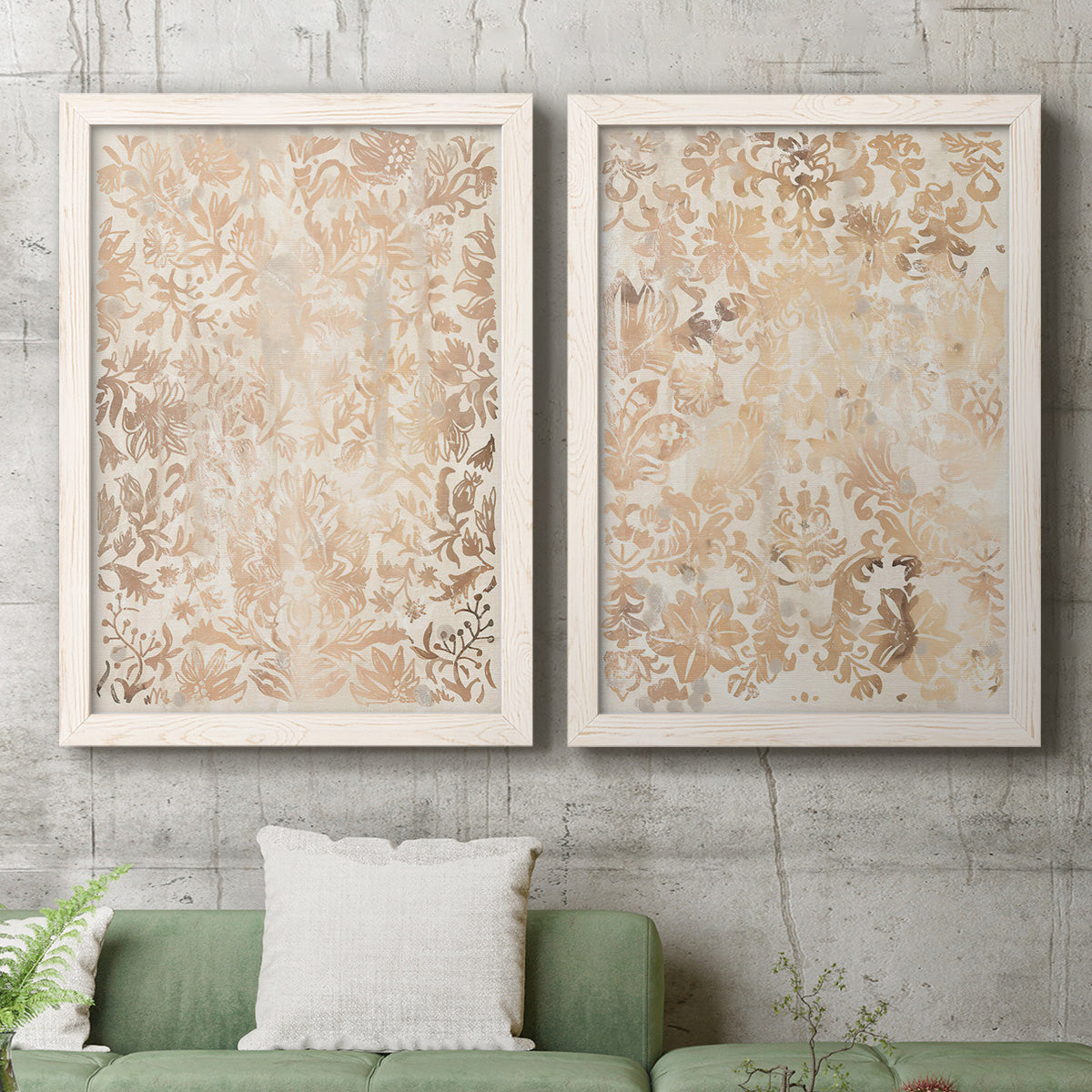 Set of two white barnwood framed canvas prints depicting a coordinated art pair of ornate cream floral damask patterns rendered as vintage decorative prints above a sofa in a modern living room.