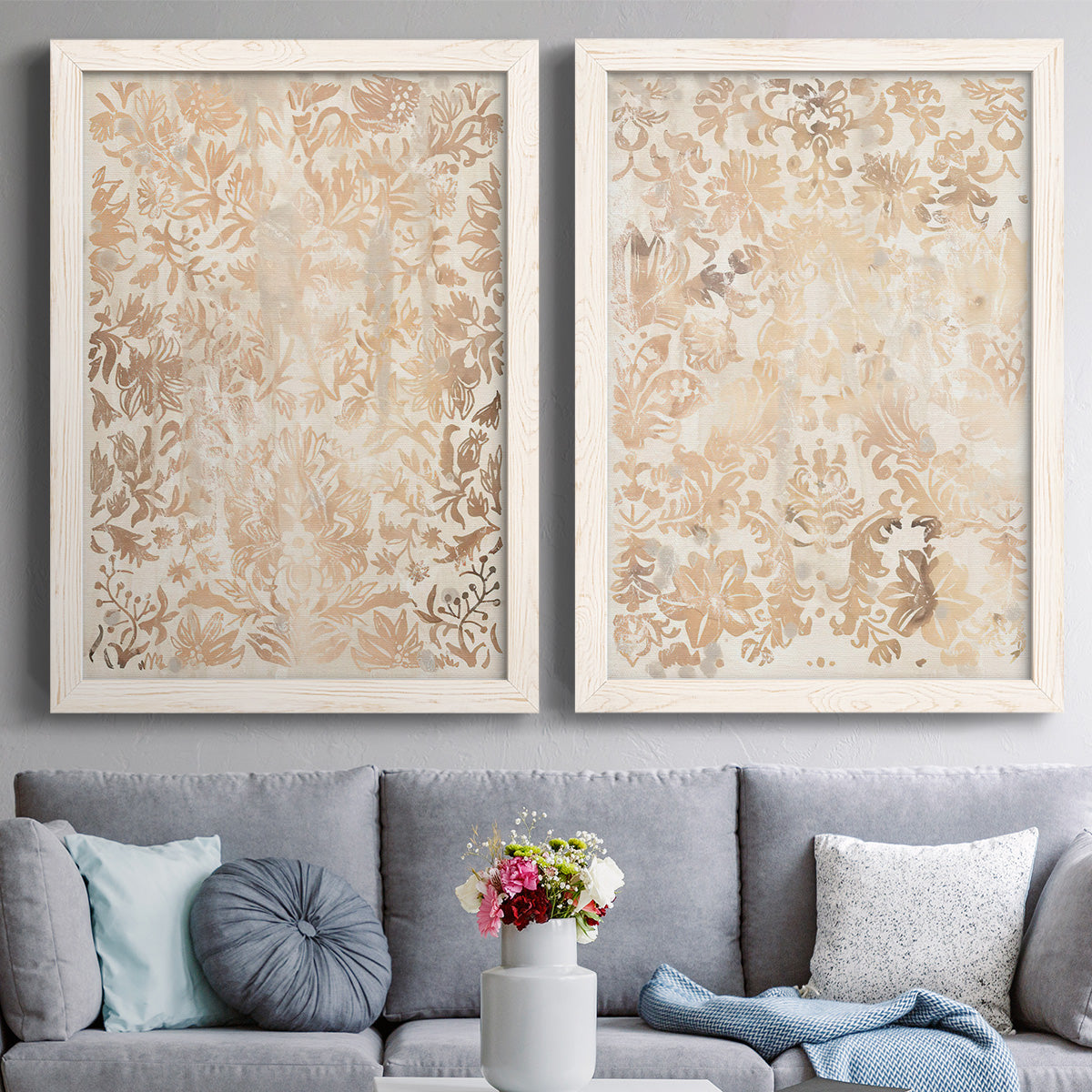 Set of two white barnwood framed canvas prints depicting paired vintage decorative prints with dense scrolling foliage, distressed walnut-brown texture, and symmetrical motifs above a sofa in a contemporary living room.