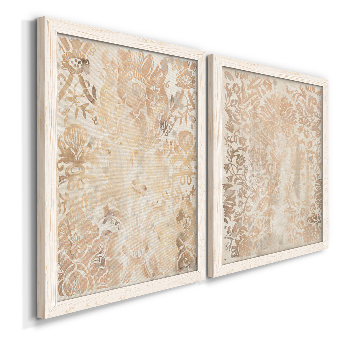 Angled view of a set of two white barnwood framed canvas prints featuring two vintage decorative prints featuring ornate cream floral damask patterns.