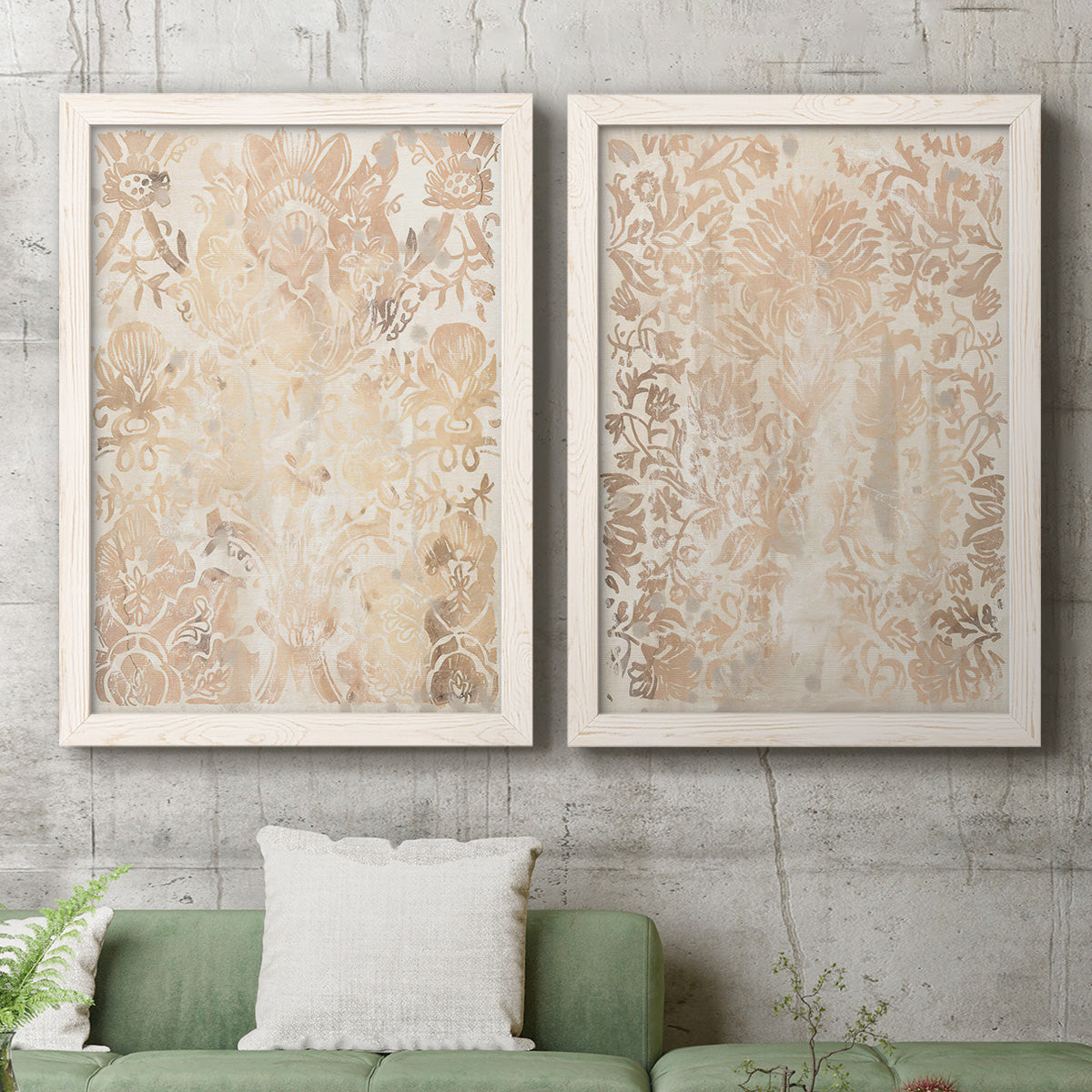 Set of two white barnwood framed canvas prints depicting a coordinated art pair of ornate cream floral damask patterns rendered as vintage decorative prints above a sofa in a modern living room.