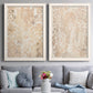 Set of two white barnwood framed canvas prints depicting paired vintage decorative prints with dense scrolling foliage, distressed walnut-brown texture, and symmetrical motifs above a sofa in a contemporary living room.