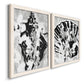 Angled view of a set of two white barnwood framed canvas prints featuring two dramatic monochrome abstracts featuring black and gray inkblot bursts.