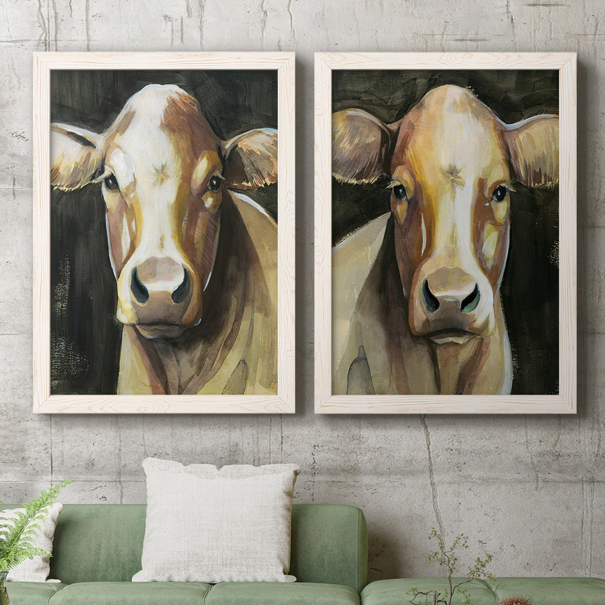 Set of two white barnwood framed canvas prints depicting a coordinated art pair of close-up portraits of gentle brown cows rendered as painterly farm-animal portraits above a sofa in a modern living room.
