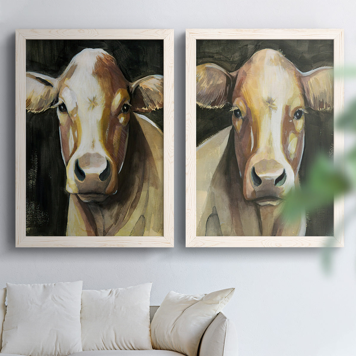 Set of two white barnwood framed canvas prints depicting large expressive eyes, warm brown faces, and dark backgrounds arranged across two complementary compositions above a sofa in a bright living space.