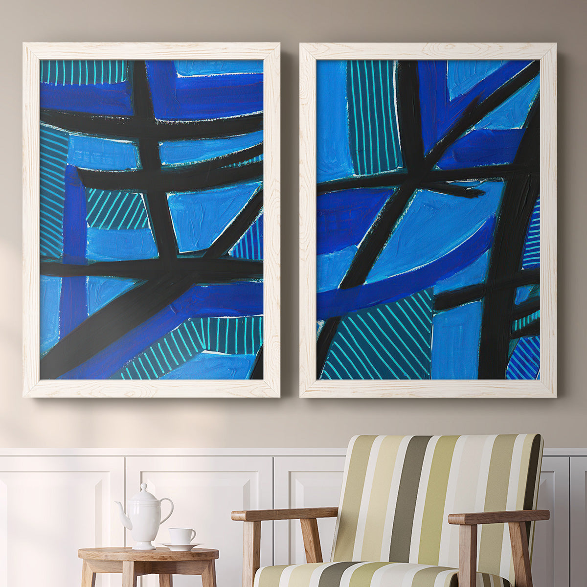 Set of two white barnwood framed canvas prints depicting two bold geometric abstracts featuring intersecting black bars over vivid blue fields above a sideboard in a cozy sitting room.