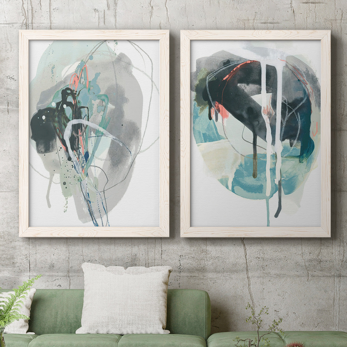 Set of two white barnwood framed canvas prints depicting a coordinated art pair of large black gray and teal circular gestures rendered as bold gestural abstracts above a sofa in a modern living room.
