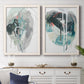 Set of two white barnwood framed canvas prints depicting a coordinated art pair of large black gray and teal circular gestures rendered as bold gestural abstracts above a dining room sideboard.