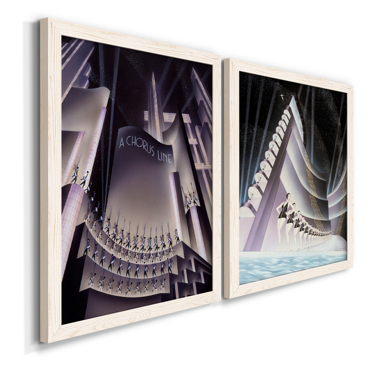 Angled view of a set of two white barnwood framed canvas prints featuring two vintage architectural illustrations featuring dramatic Art Deco city and theater scenes.