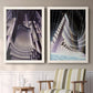 Set of two white barnwood framed canvas prints depicting two vintage architectural illustrations featuring dramatic Art Deco city and theater scenes above a sideboard in a cozy sitting room.