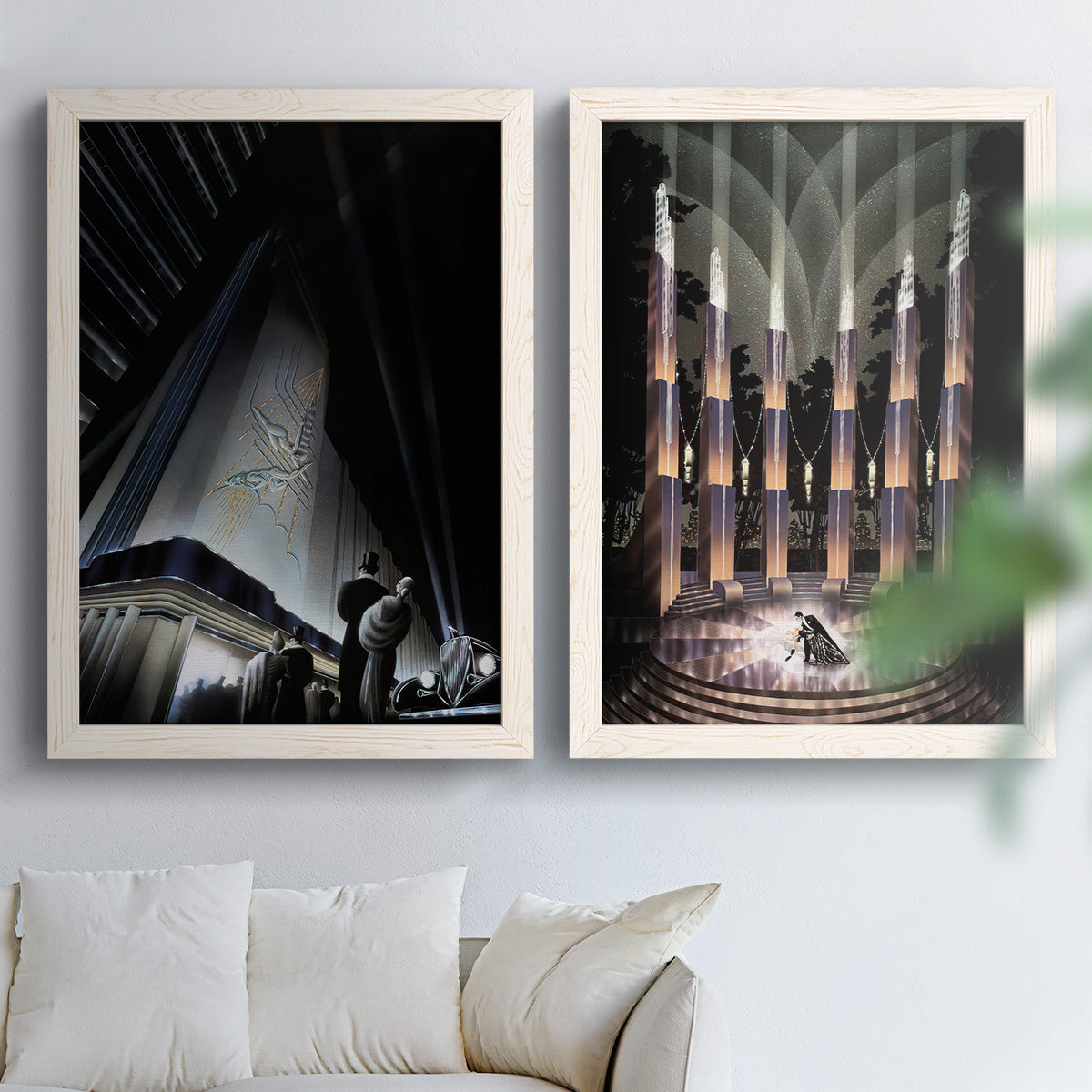 Set of two white barnwood framed canvas prints depicting monumental skyscrapers, sweeping stairways, spotlights, and elegant nighttime figures arranged across two complementary compositions above a sofa in a bright living space.