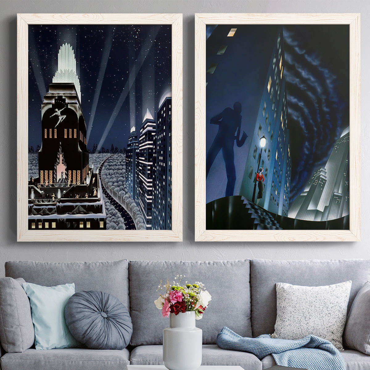 Set of two white barnwood framed canvas prints depicting glamorous nighttime cityscapes with deco towers dramatic perspective and mysterious silhouetted figures above a sofa in a contemporary living room.