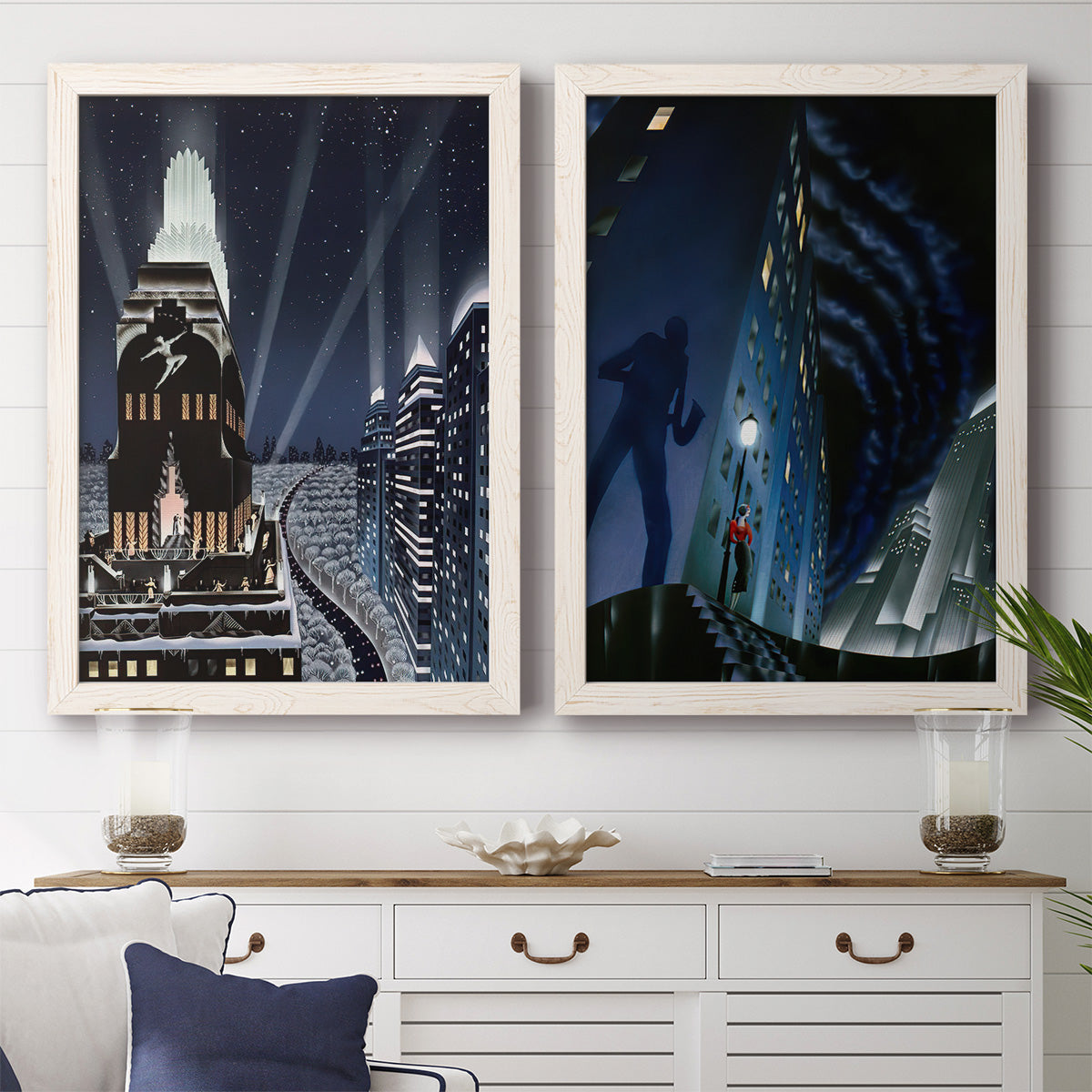 Set of two white barnwood framed canvas prints depicting a vintage urban pair of towering architecture searchlights stars and shadowed people at night above a dining room sideboard.