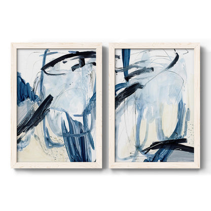 Set of two white barnwood framed canvas prints featuring two expressive blue abstracts featuring sweeping indigo and black gestural brushwork.