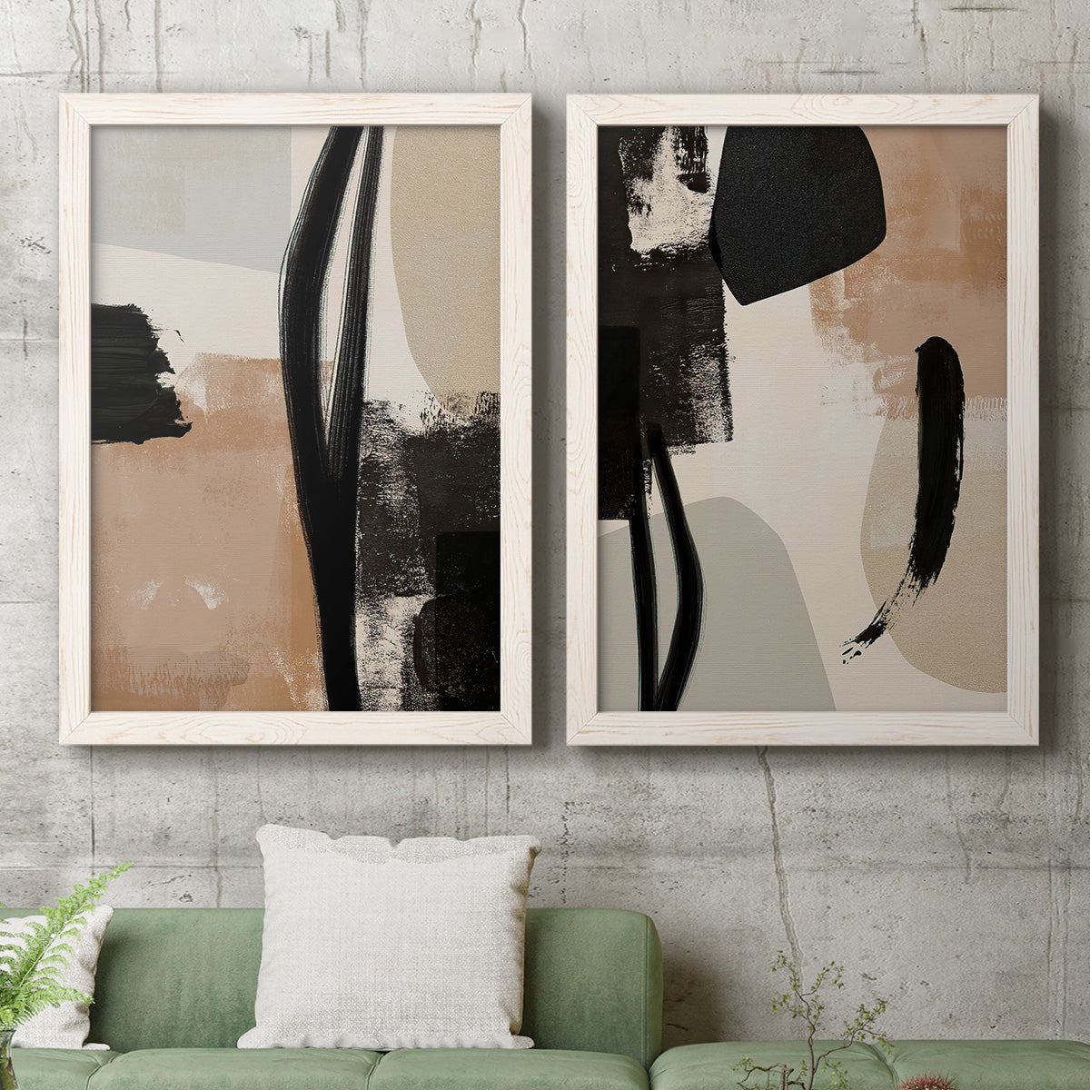 Set of two white barnwood framed canvas prints depicting a coordinated art pair of black taupe cream and beige painted forms rendered as minimalist collage-like abstracts above a sofa in a modern living room.