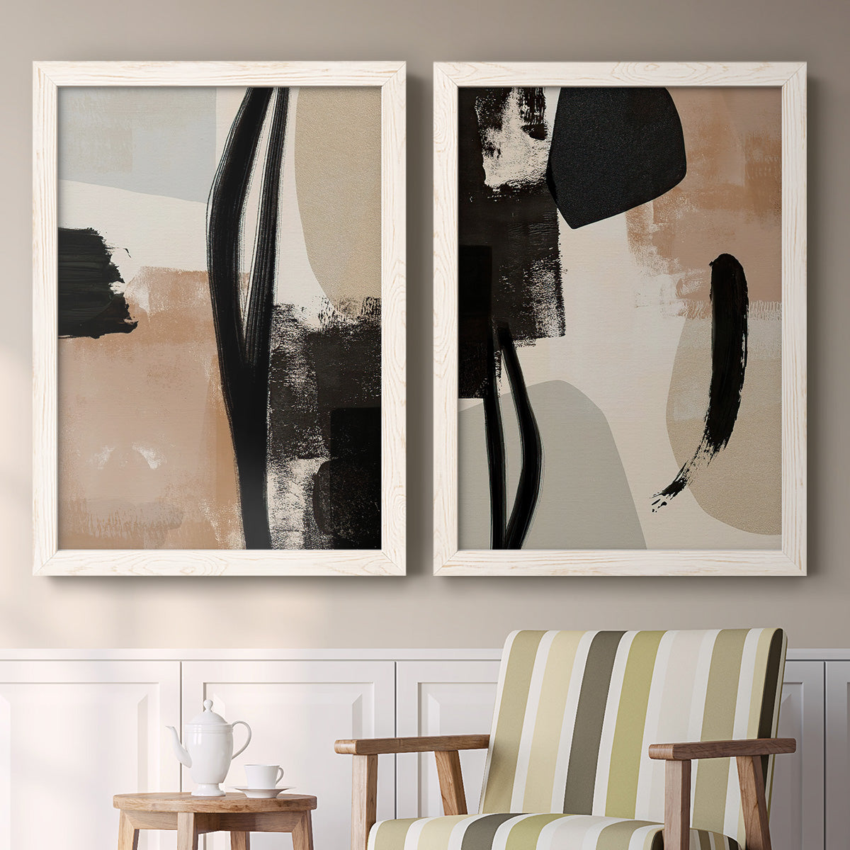 Set of two white barnwood framed canvas prints depicting two minimalist collage-like abstracts featuring black taupe cream and beige painted forms above a sideboard in a cozy sitting room.