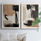 Set of two white barnwood framed canvas prints depicting bold brush arcs, blocky shapes, and spacious neutral grounds arranged across two complementary compositions above a sofa in a bright living space.