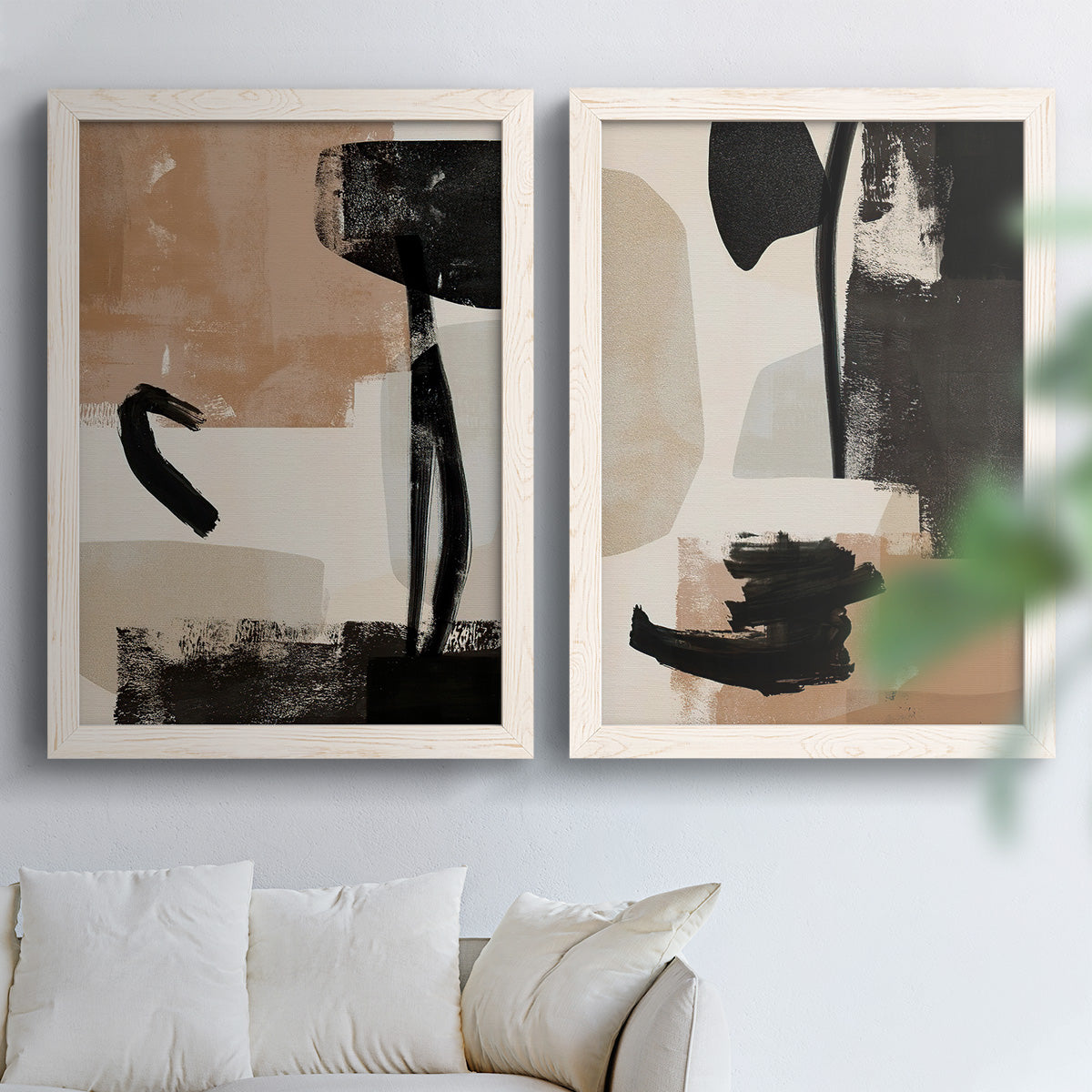 Set of two white barnwood framed canvas prints depicting bold brush arcs, blocky shapes, and spacious neutral grounds arranged across two complementary compositions above a sofa in a bright living space.