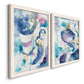 Angled view of a set of two white barnwood framed canvas prints featuring two colorful lyrical abstracts featuring lively blue pink violet and turquoise watercolor gestures.