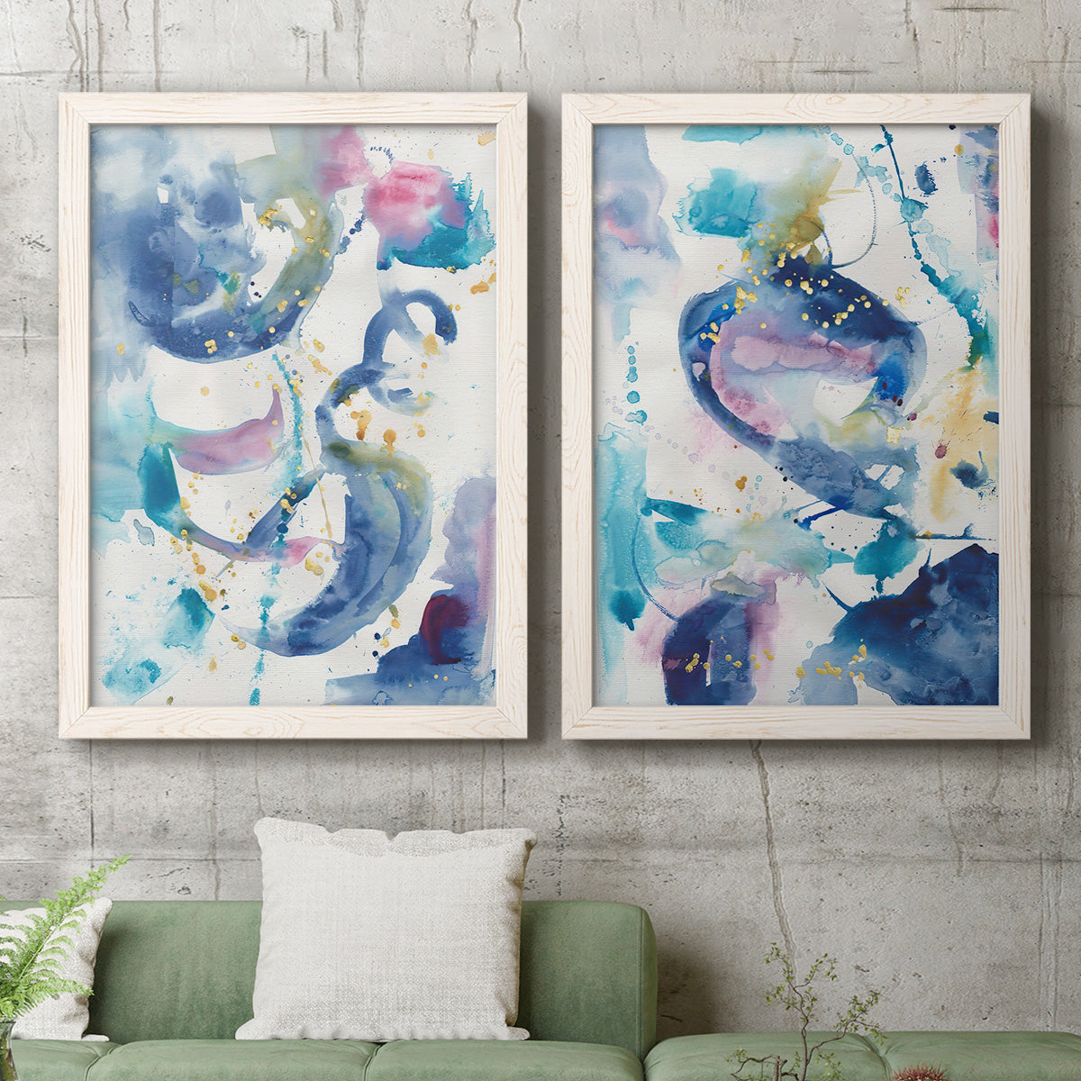 Set of two white barnwood framed canvas prints depicting a coordinated art pair of lively blue pink violet and turquoise watercolor gestures rendered as colorful lyrical abstracts above a sofa in a modern living room.