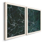 Angled view of a set of two white barnwood framed canvas prints featuring two dramatic stone-inspired abstracts featuring dark green marble veining.