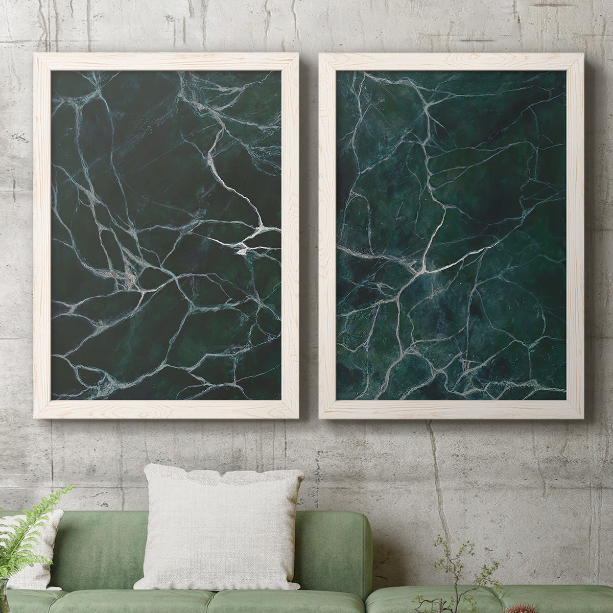 Set of two white barnwood framed canvas prints depicting a coordinated art pair of dark green marble veining rendered as dramatic stone-inspired abstracts above a sofa in a modern living room.