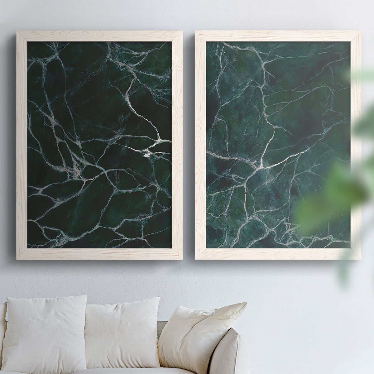 Set of two white barnwood framed canvas prints depicting deep jade fields, fine white cracks, and glossy mineral texture arranged across two complementary compositions above a sofa in a bright living space.