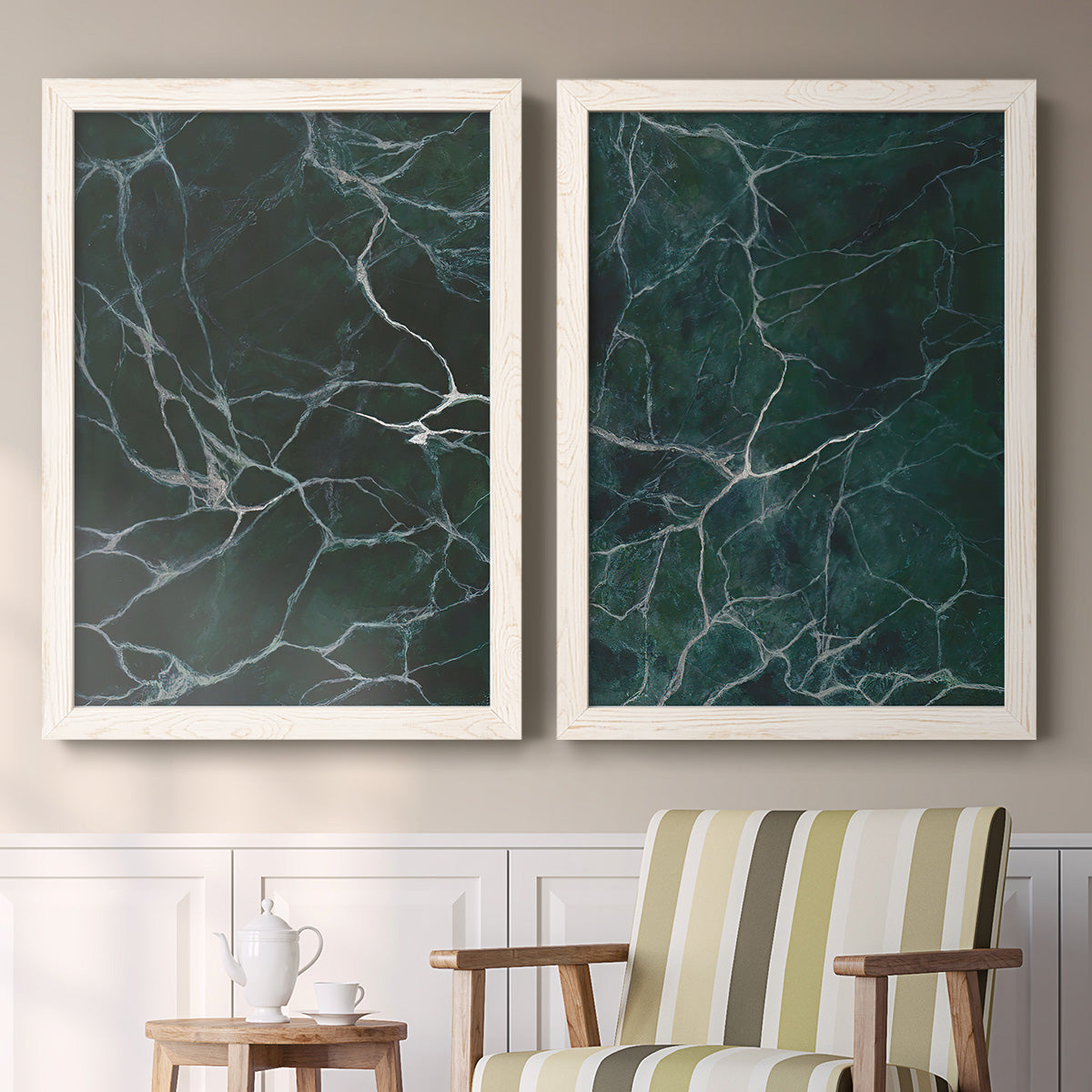 Set of two white barnwood framed canvas prints depicting two dramatic stone-inspired abstracts featuring dark green marble veining above a sideboard in a cozy sitting room.