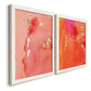 Angled view of a set of two white barnwood framed canvas prints featuring two glamorous fluid abstracts featuring luminous coral orange and pink color fields with gold flecks.