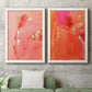 Set of two white barnwood framed canvas prints depicting a coordinated art pair of luminous coral orange and pink color fields with gold flecks rendered as glamorous fluid abstracts above a sofa in a modern living room.