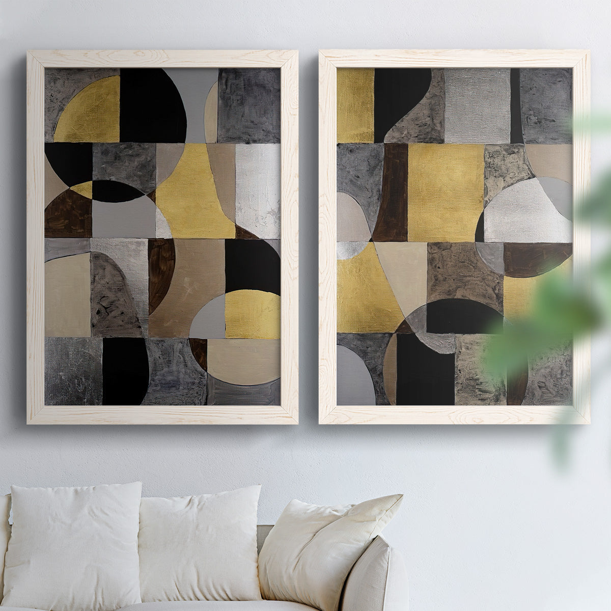 Set of two white barnwood framed canvas prints depicting semicircles, rectangles, textured panels, and metallic-looking accents arranged across two complementary compositions above a sofa in a bright living space.