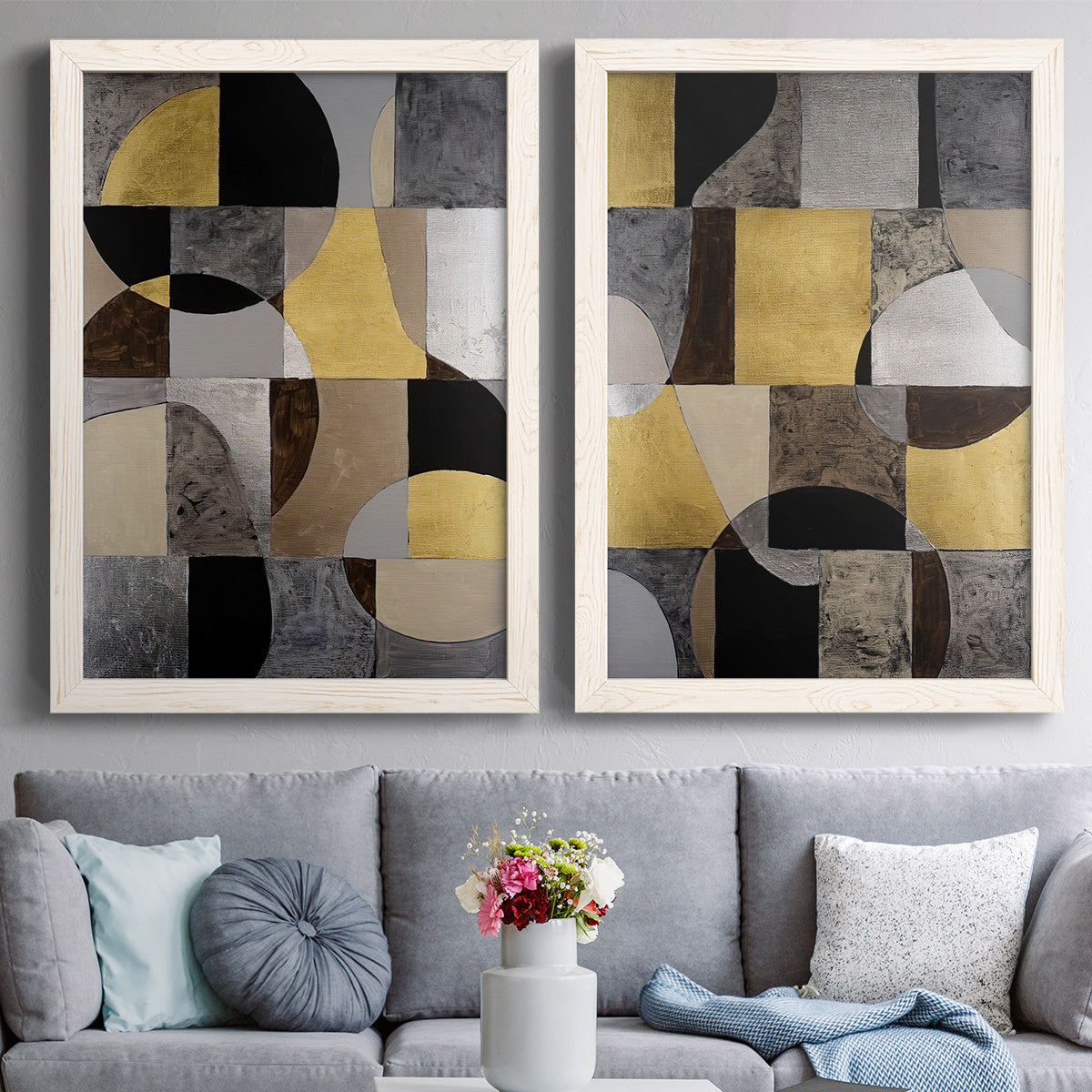 Set of two white barnwood framed canvas prints depicting paired structured modern abstracts with semicircles, rectangles, textured panels, and metallic-looking accents above a sofa in a contemporary living room.